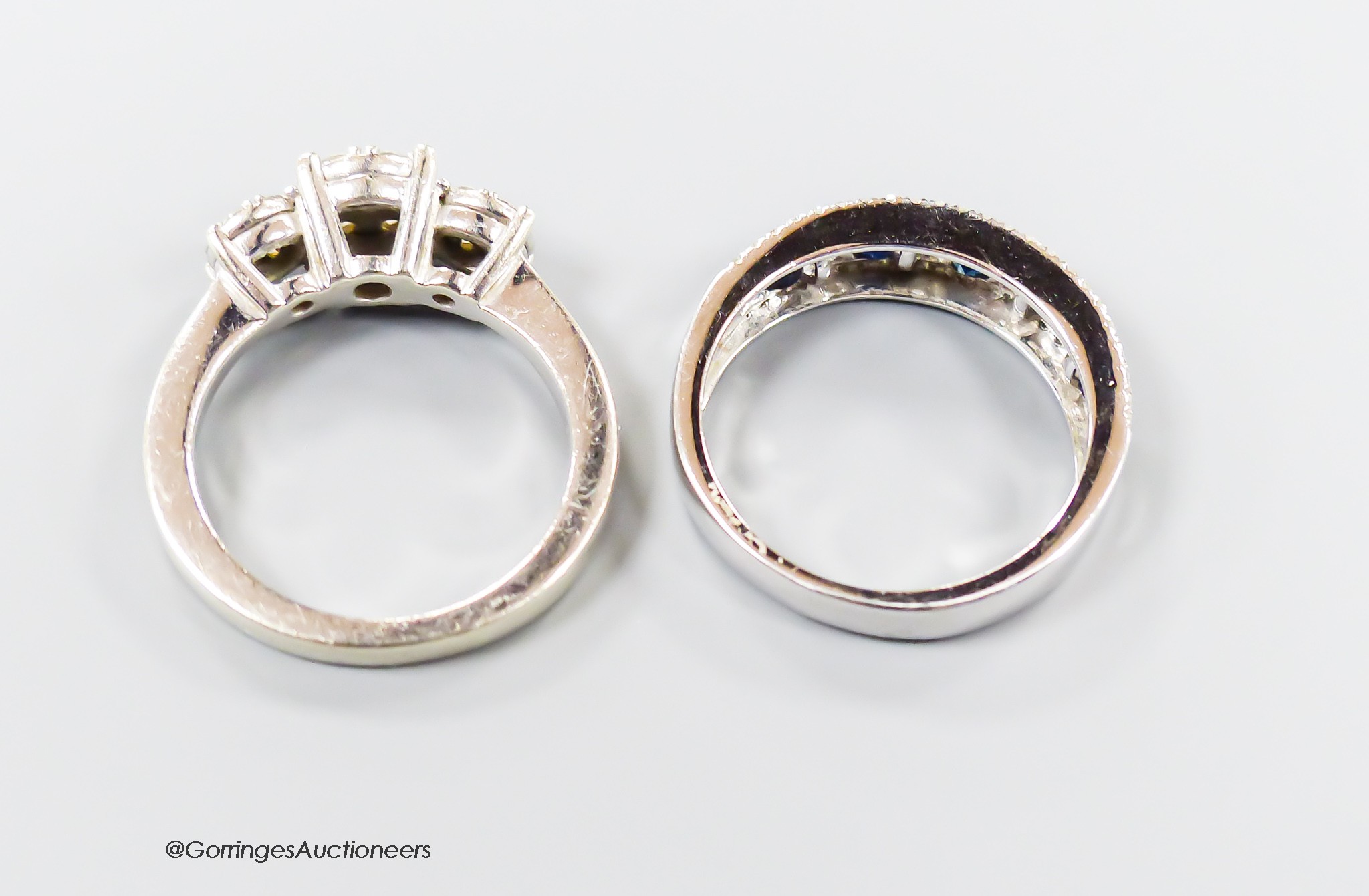 A modern 9ct white gold and triple diamond cluster set dress ring, size I/J and a similar sapphire and diamond set half hoop ring, size K, gross 6.5 grams.